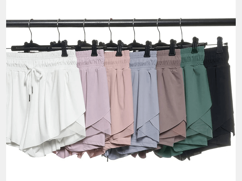 Colorful nylon gym shorts for women hanging on a rack, featuring breathable and quick-dry fabric, perfect for yoga and running workouts.